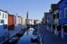 A foreshortened view of a Burano's canal with its coloured houses, boats and bell-tower - Burano in Venice, JBLArts photography